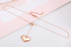 Detailed close-up of rose gold stainless steel heart pendant with adjustable slider bead chain