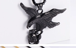 Macro detail of black eagle skull pendant with spread wings and textured metal finish