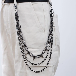 Three-layer punk jeans chain with sharp spikes in dark grey metal finish on white trousers