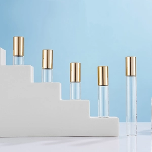 Clear glass roller bottles in 1ml to 10ml sizes with elegant gold caps on white steps
