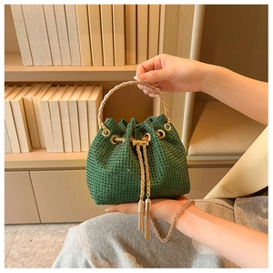 Detail of green rhinestone bucket bag with gold handle and tassel drawstring closure
