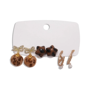 Six-piece earring set featuring leopard fur balls and sparkling rhinestone stars on white card