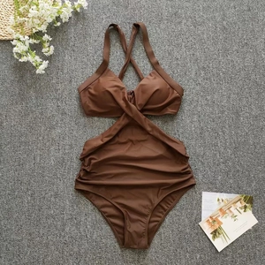 Detail of deep brown one-piece swimsuit featuring crossover neckline and waist cut-out