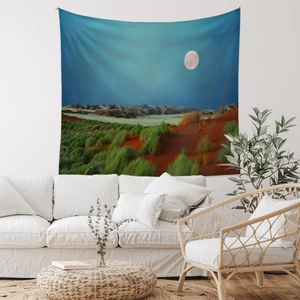 Detailed desert moon landscape tapestry hanging over a sofa in a modern room