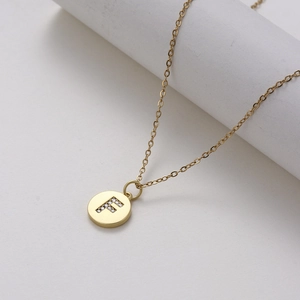Macro shot of gold stainless steel necklace with sparkling zircon letter F pendant