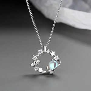 Detailed close-up of a silver cosmic planet necklace with star moon motifs and zircons