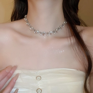 Close-up of pearl heart necklace with rhinestones worn on a model's neck