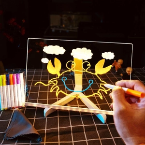 Macro view of hand drawing on a transparent LED acrylic glow board with colorful markers