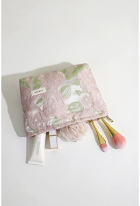 Vue détaillée de la trousse de maquillage rose jacquard avec relief floral