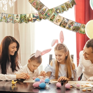 Family decorating eggs under a vintage Easter party bunting with bunny and chick motifs