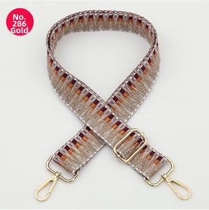 Detail of ethnic style woven bag strap in orange and brown with gold metal buckles