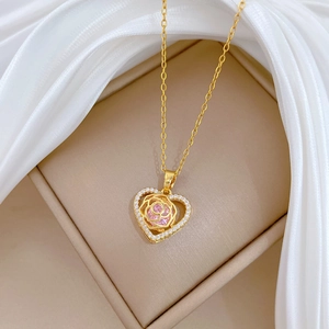 Elegant gold heart necklace with pink rose crystal and diamonds on white silk fabric