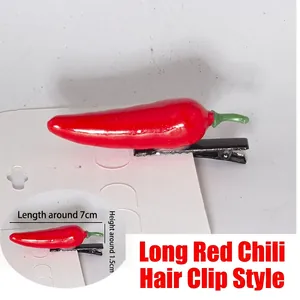 Macro detail of a 7cm red chili hair clip made of shiny resin on a metal duckbill clip