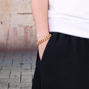 Detail view of iced out Cuban link bracelet in gold finish on a male wrist