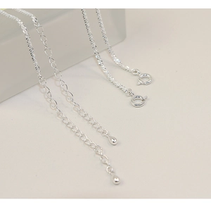 Macro detail of 925 sterling silver necklaces featuring extension chains and spring clasps