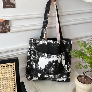 Dettaglio della borsa tote in tela artistica con schizzi d'inchiostro bianco e nero