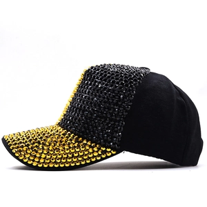 Close-up of sparkling gold and black rhinestones on a stylish black baseball cap