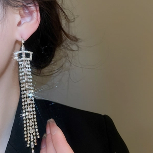 Close-up of silver tassel earrings with sparkling rhinestones worn by a model