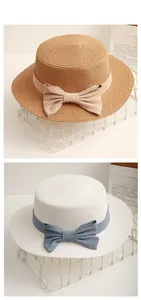 Detail of straw boater hat with striped bow ribbon decoration and woven texture
