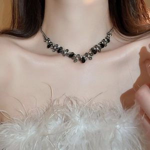 Close-up of a layered silver-plated necklace set with black and white teardrop rhinestones