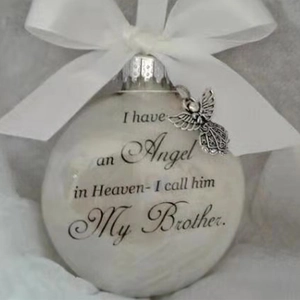 Detailed view of commemorative Christmas feather ball with ribbon and angel wing charm