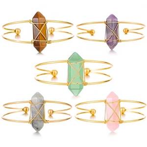 Detalle de cinco brazaletes de hilo dorado con varios cristales hexagonales de colores naturales