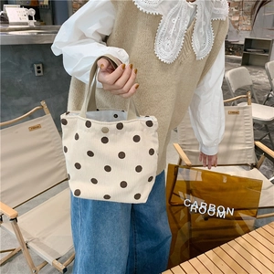 Detailed macro view of beige corduroy tote with brown polka dots and snap button closure