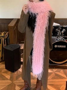 Chic pink long faux fur scarf accessory styled with a brown winter coat in a music room
