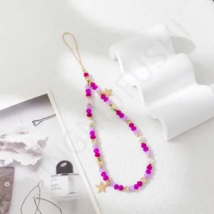 Detail of beaded phone strap with pink faceted beads and golden star pendants