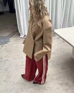 Side view of an oversized camel blazer with shoulder pads and side slits on a model