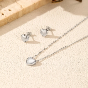 Minimalist S925 silver heart jewelry set with necklace and earrings on stone surface