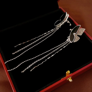 Macro view of butterfly long tassel earrings with black enamel in a red jewelry box