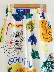 Détail du pantalon blanc avec imprimés graffiti abstraits et taille élastiquée