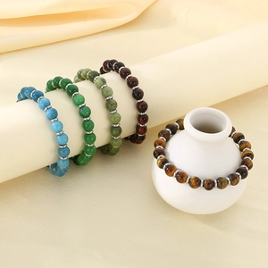 Detailed macro view of natural tiger eye and lava stone bracelets with metal spacers