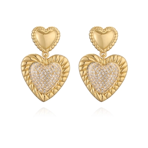 Elegant gold double heart dangle earrings with sparkling crystals on white background