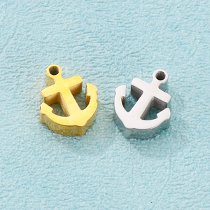 Close-up of DIY stainless steel anchor charms in polished gold and silver finishes