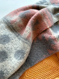 Close-up of pink and grey polka dot cashmere-like scarf showing soft plush texture