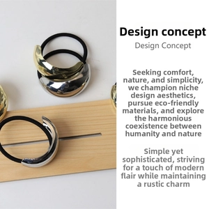 Detailed view of minimalist high-shine gold and silver metal charms on black elastic hair ties