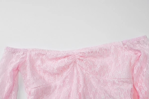 Close-up detail of the pink lace stitching and off-shoulder design on this fishtail evening gown