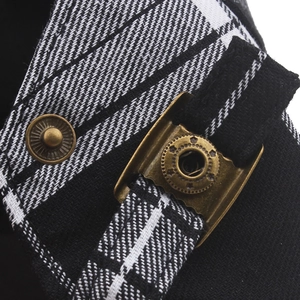 Macro shot of retro metal buckle and adjustable strap on black and white plaid newsboy cap