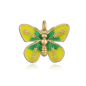 Macro detail of golden butterfly pendant with yellow enamel and floral wing patterns
