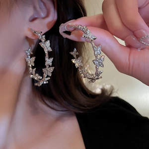 Silver butterfly hoop earrings with crystals shown on a model for a stylish look