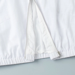 Detailed macro view of white vest jacket texture with silver metal zipper and elastic hem