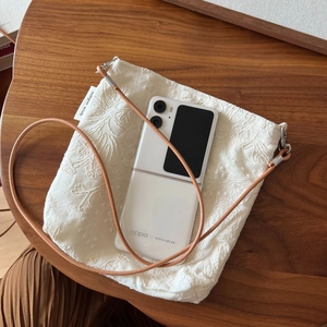 Close-up of beige linen floral embroidery crossbody bag with a slim leather strap