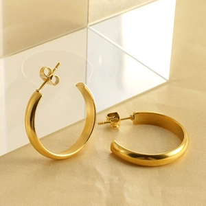 Minimalist 18k gold plated stainless steel C-shaped hoop earrings on elegant background