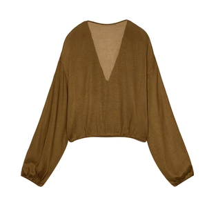 Detail view of V-neck ruffled blouse in brown with elastic cuffs and lightweight fabric