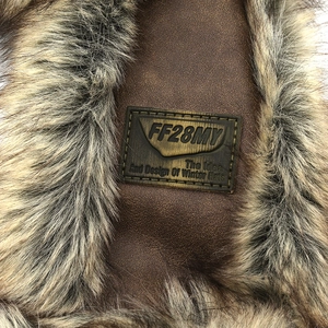 Detail of vintage brown leather winter hat featuring thick faux fur and stitched label logo