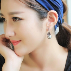 Vintage luxury sun flower earrings with silver grey pearls on model profile view