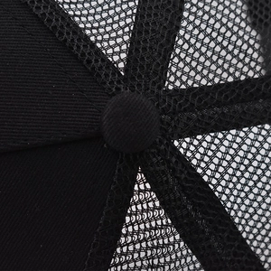 Close-up of black mesh trucker hat top button and reinforced stitched panels details
