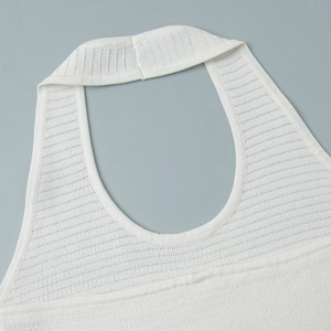 Detail of white knit halter neckline with fine ribbed texture and clean finish